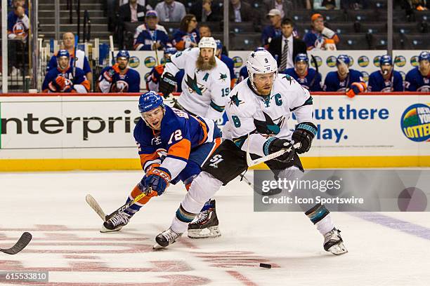 New York Islanders Left Wing Anthony Beauvillier reaches around San Jose Sharks Center Joe Pavelski during the first period of a NHL game between the...