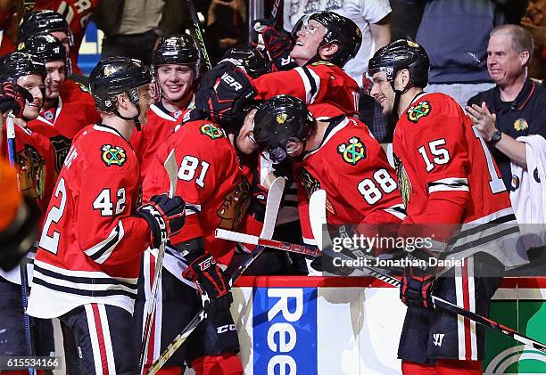 Marian Hossa of the Chicago Blackhawks is mobbed by teammates including Gustav Forsling, Jonathan Toews, Patrick Kane and Artem Anisimov after...
