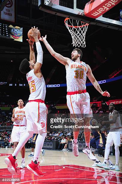 Ryan Kelly and DeAndre Bembry of the Atlanta Hawks jump for the rebound during a preseason game against the New Orleans Pelicans on October 18, 2016...