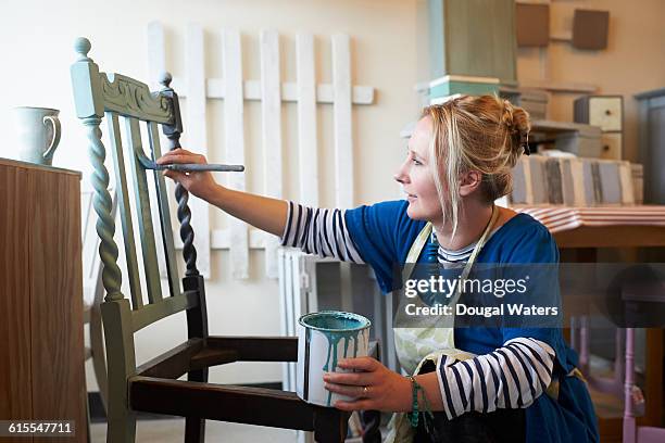 woman painting chair in workshop. - overhaul stock pictures, royalty-free photos & images
