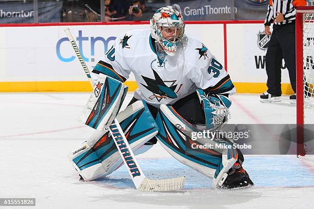 Aaron Dell and Paul Martin of the San Jose Sharks defends the net against the New York Islanders at the Barclays Center on October 18, 2016 in...