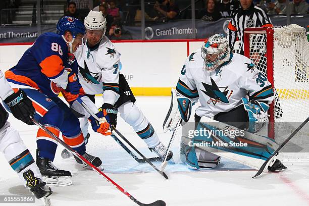 Aaron Dell of the San Jose Sharks defends the net against Nikolay Kulemin of the New York Islanders at the Barclays Center on October 18, 2016 in...