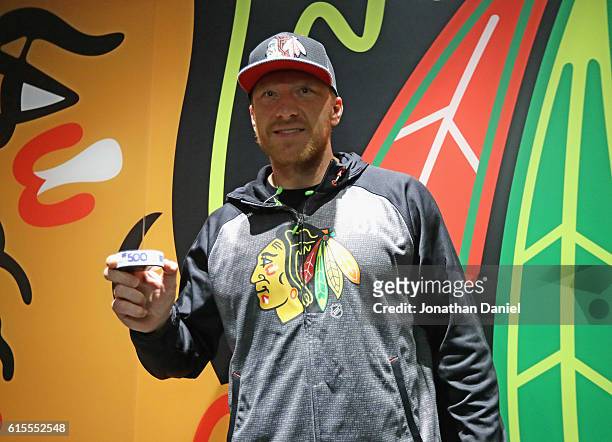 Marian Hossa of the Chicago Blackhawks poses with the puck after scoring his 500th career goal against the Philadelphia Flyers at the United Center...