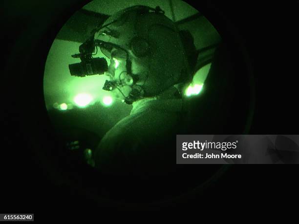 Customs and Border Protection helicopter pilot with night vision goggles patrols over the U.S.-Mexico border on October 18, 2016 in McAllen, Texas....