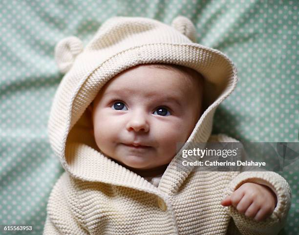 a baby girl laying on a bed - sólo bebés fotografías e imágenes de stock