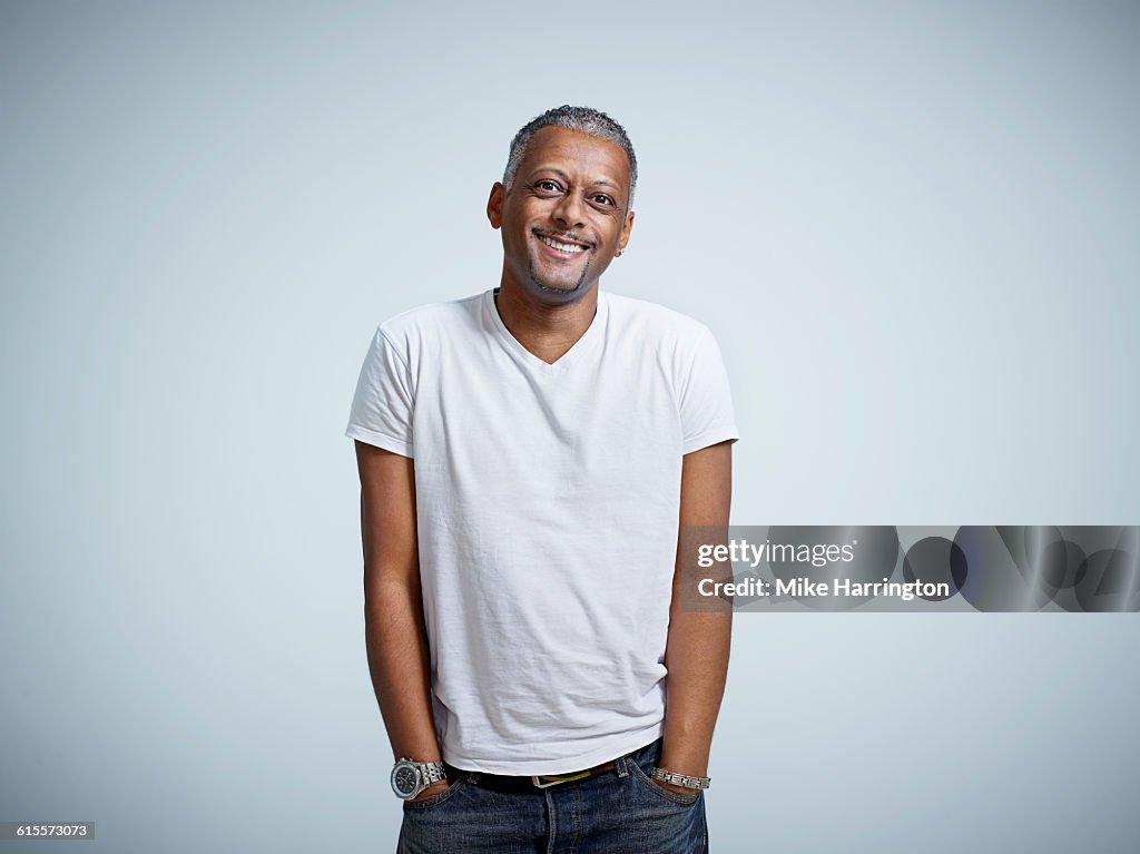 Mature male smiling with hands in pockets