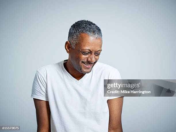 mature black male looking down and smiling - mit dem gesicht nach unten stock-fotos und bilder