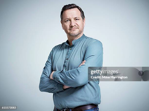 portrait of mature male with arms crossed - blaues hemd stock-fotos und bilder