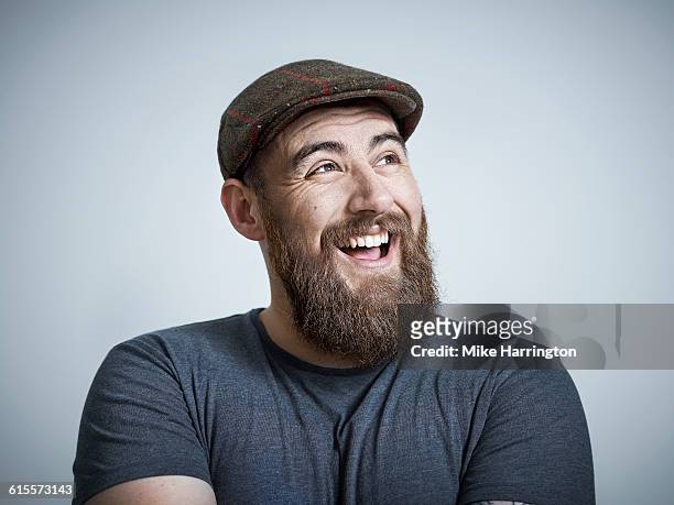 young bearded male laughing - flat cap stock pictures, royalty-free photos & images