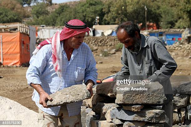 Syrians, who live in makeshift tents at al-Burayqah camp near Golan Heights, try to build houses using stones, mud-bricks and zinc plates to get...