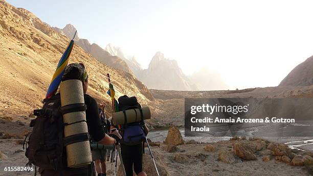 trekkers getting to frontal moraine of baltoro glacier. karakorum range, pakistan. - moräne stock-fotos und bilder