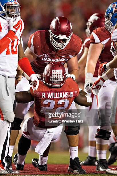 Rawleigh Williams III is picked up off the ground by Dan Skipper of the Arkansas Razorbacks during a game against the Mississippi Rebels at Razorback...