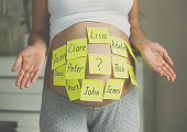 Toned shot of pregnant woman with child names on belly