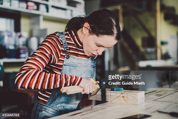 woman working in carpentry. - jeans latzhose frau stock-fotos und bilder