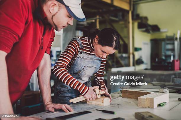 carpenter and trainee in carpentry. - jeans latzhose frau stock-fotos und bilder