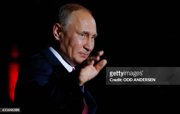 Russian President Vladimir Putin waves upon arrival at the chancellery on October 19, 2016 in Berlin. - German Chancellor Angela Merkel hosts the...