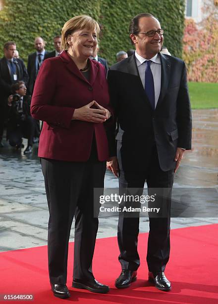 German Chancellor Angela Merkel and French President Francois Hollande arrive to discuss the Ukrainian peace process at the German federal...