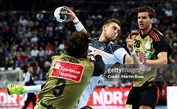 Mykola Bilyk of Kiel challenges for the ball with Mait Patrail and Erik Schmidt of Hannover-Burgdorf during the DKB HBL Bundesliga match between THW...