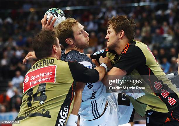 Steffen Weinhold of Kiel challenges for the ball with Fabian Boehm and Joakim Hykkerud of Hannover-Burgdorf during the DKB HBL Bundesliga match...