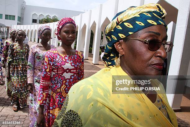 Nigerian Women's Affairs minister Hajia Aisha al-Hassan leads the 21 Chibok girls who were released by Boko Haram last week, as they arrive on...