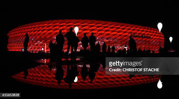 Spectators walk outside the stadium ahead the UEFA Champions League group D football match FC Bayern Munich vs PSV Eindhoven in Munich, on October...