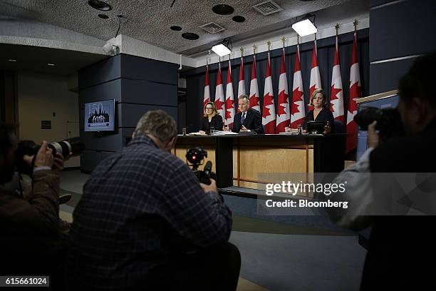 Stephen Poloz, governor of the Bank of Canada, center, speaks as Carolyn Wilkins, senior deputy governor at the Bank of Canada, left, listens during...