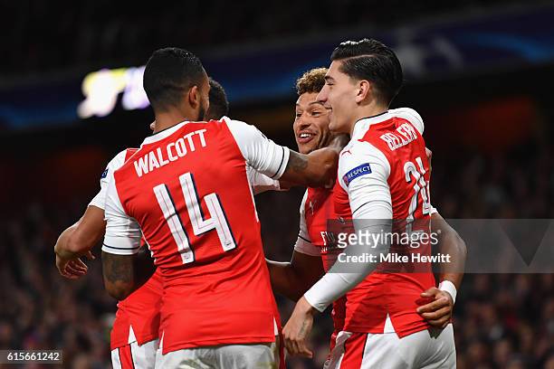 Alex Oxlade-Chamberlain of Arsenal celebrates with team mates after scoring his team's third goal of the game during the UEFA Champions League group...
