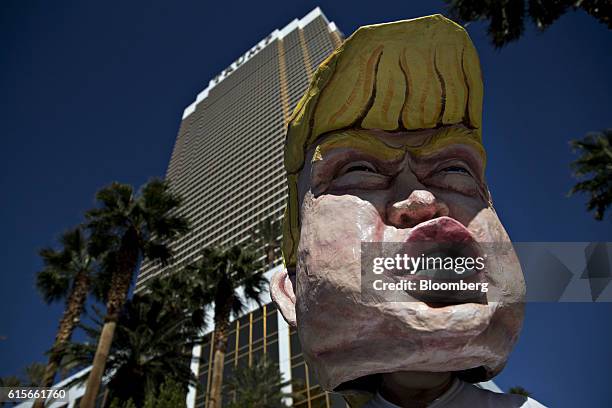 Demonstrator wears a Donald Trump, 2016 Republican presidential nominee, mask outside the Trump International Hotel Las Vegas ahead of the third U.S....