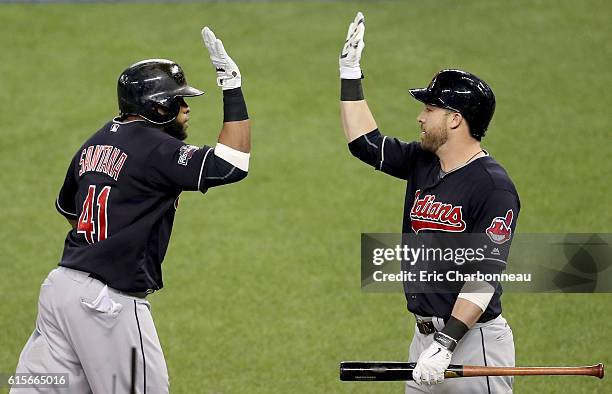 Carlos Santana of the Cleveland Indians celebrates with teammate Jason Kipnis after hitting a solo home run in the third inning against Marco Estrada...
