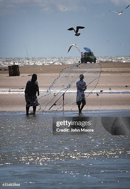 Birds pass by fishermen on the Mexican side of the Rio Grande on October 19, 2016 in Boca Chica, Texas. The mouth of the river, which flows into the...