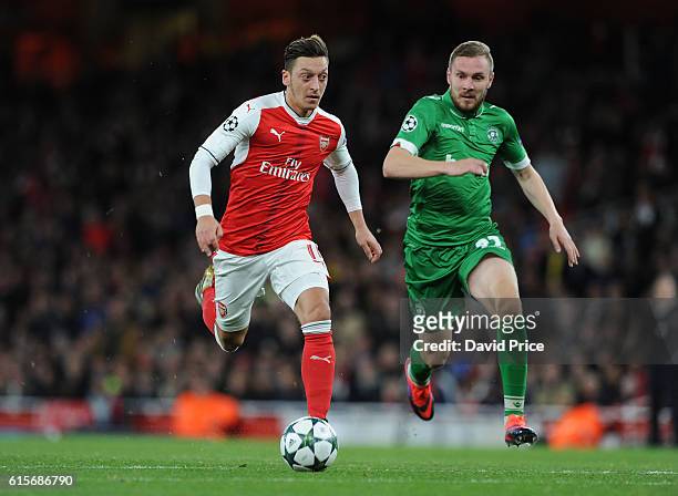 Mesut Ozil on his way to scoring Arsenal's 4th goal under pressure from Cosmin Moti of Ludogorets during the UEFA Champions League match between...