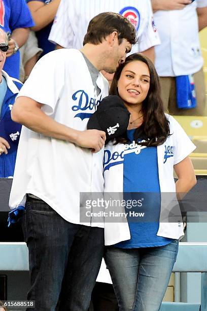 Ashton Kutcher and wife Mila Kunis on the field after they announced the Los Angeles Dodgers starting lineup before game four of the National League...