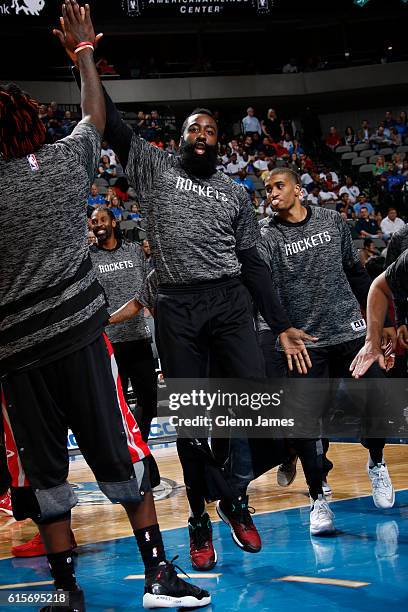 James Harden of the Houston Rockets high fives teammates before a preseason game on October 19, 2016 at the American Airlines Center in Dallas,...