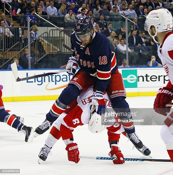 Marc Staal of the New York Rangers holds down Justin Abdelkader of the Detroit Red Wings during the first period at Madison Square Garden on October...