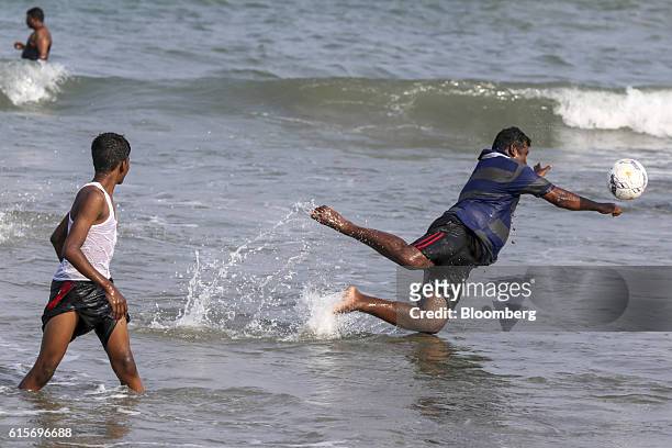 Visitor jumps for a football while in the sea at Velankanni Beach in Nagapattinam, Tamil Nadu, India, on Saturday, Oct. 15, 2016. India's new central...