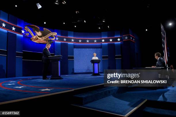 Republican presidential nominee Donald Trump , Democratic presidential nominee Hillary Clinton and moderator Chris Wallace wait to begin the final...