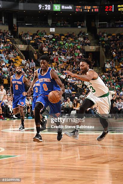 Justin Holiday of the New York Knicks brings the ball up court against James Young of the Boston Celtics on October 19, 2016 at the TD Garden in...