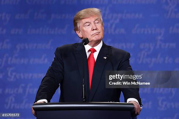 Republican presidential nominee Donald Trump listens to Democratic presidential nominee former Secretary of State Hillary Clinton speak during the...