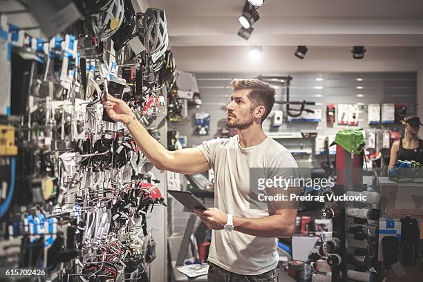 homme dans un magasin de vélos - magasin de sport photos et images de collection