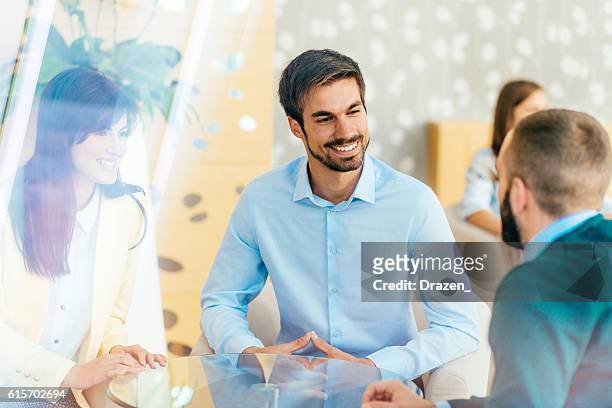discussion between friend in hotel lobby - female with group of males stock pictures, royalty-free photos & images