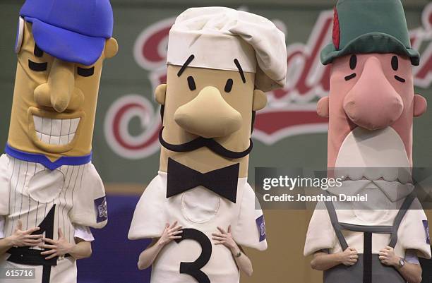 Human bobbleheads representing a baseball player, a chef and a German flugelhorn player stand on the field during the MLB game between the Milwaukee...