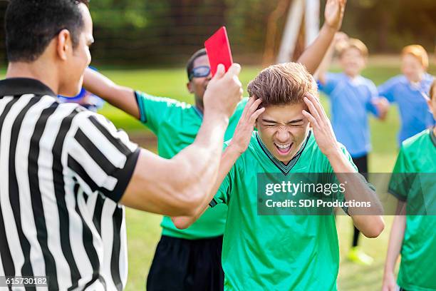 hispanic soccer player yells while being shown red card - fault sports stock pictures, royalty-free photos & images