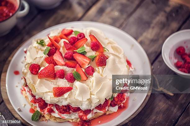 berry pavlova kuchen mit erdbeeren und himbeeren - meringe stock-fotos und bilder