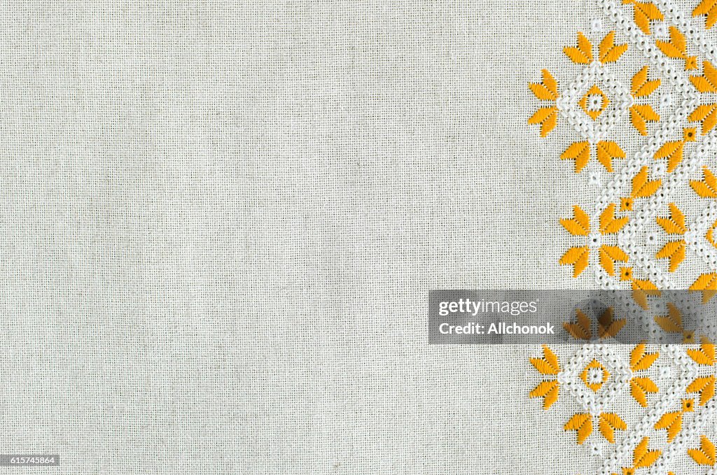 Embroidered fragment on flax by yellow and white cotton threads.