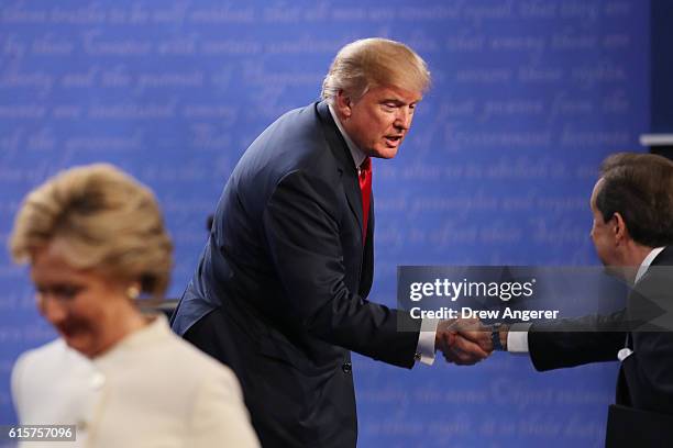 Republican presidential nominee Donald Trump shakes hands with Fox News anchor and moderator Chris Wallace as Democratic presidential nominee former...