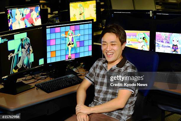 Japan - Graphics designer Atsushi Wakamura smiles in Tokyo on Oct. 3 in front of computer panels showing promotion videos he has created for Hatsune...