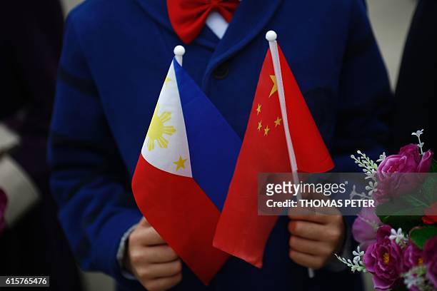 Child holds the national flags of China and the Philippines before Philippines President Rodrigo Duterte and China's President Xi Jinping attend a...