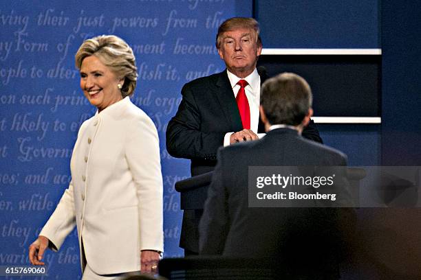 Donald Trump, 2016 Republican presidential candidate, stands as Hillary Clinton, 2016 Democratic presidential candidate, exits the stage after the...