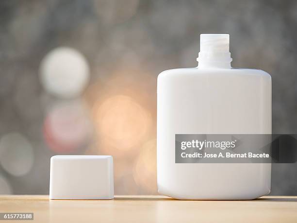 blank cosmetics containers, close up, aftershave,  illuminated by sunlight - aftershave bottle stock-fotos und bilder