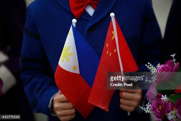 Children hold plastic flowers, national flags of China and the Philippines before President of the Philippines Rodrigo Duterte and China's President...